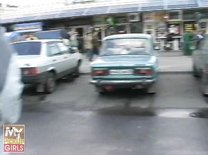Возле машины брюнетка в чулках занимается анальным сексом