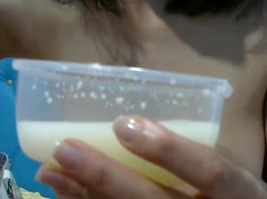 Женщина цедит из груди молоко в стакан