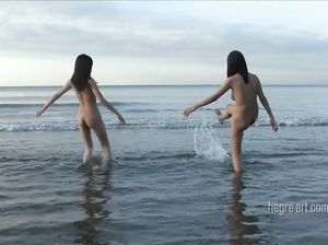 Две молодые брюнетки развлекаются на пляже нудистов