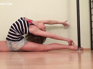 Улыбающаяся молодая спортсменка соблазняет зрителя подтянутым телом